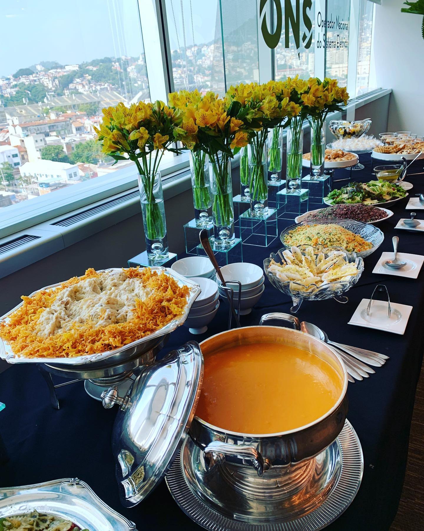 Ilha de buffet com pratos e arranjos florais